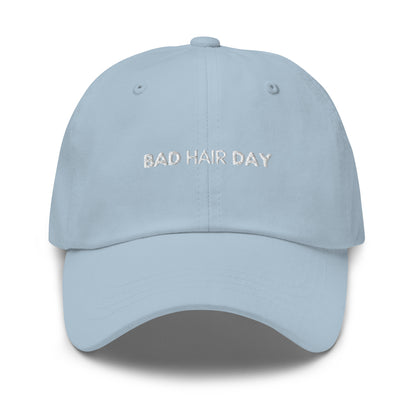 a light hat with white sarcastic, bad hair day, text on it