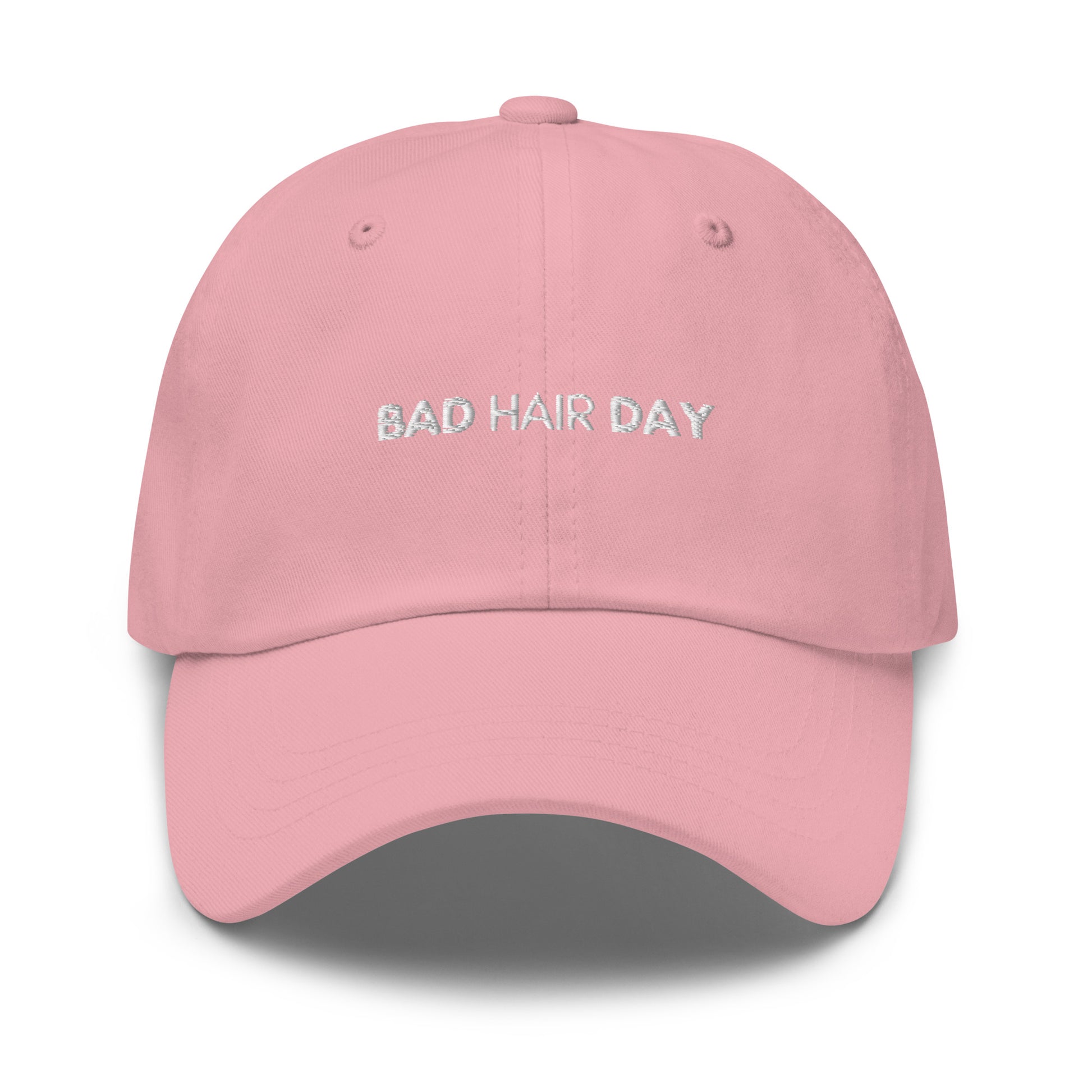 a pink hat with white sarcastic, bad hair day, text on it